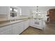 Bright kitchen featuring tile floors, white cabinets, modern stove and sink overlooking fireplace at 4041 Wendy Ln, Zebulon, NC 27597