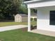 View of an exterior storage building located in the backyard, featuring a gravel driveway and manicured lawn at 412 N Green St, Selma, NC 27576