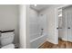 Bathroom with a white tub and a matching toilet with wood-style flooring at 412 N Green St, Selma, NC 27576