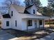 Charming white two-story home with a welcoming front porch and dark-framed windows at 412 N Green St, Selma, NC 27576