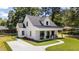 Charming two-story white home featuring a welcoming front porch and freshly manicured lawn at 412 N Green St, Selma, NC 27576