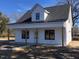 Charming white two-story home featuring a welcoming front porch and black roof at 412 N Green St, Selma, NC 27576