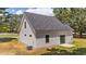 View of home's exterior featuring white siding, dark roof, windows and glass doors with a small cement patio at 412 N Green St, Selma, NC 27576