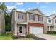 Charming two-story home with tan siding, brick accents, and a well-maintained front yard with colorful flowers at 434 Golden Villas Dr, Rocky Mount, NC 27809