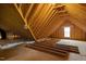 Unfinished attic space with exposed beams and a small window at 4840 Baines Loop Rd, Spring Hope, NC 27882