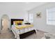 A cozy bedroom featuring a large bed with decorative pillows and natural light from two windows at 4840 Baines Loop Rd, Spring Hope, NC 27882