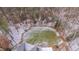 Breathtaking aerial view of a property featuring a well-kept lawn, stone patio, and surrounded by lush trees at 659 Willard Dr, Creedmoor, NC 27522