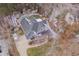 Striking aerial view of a gray home with a dark roof and an expansive driveway surrounded by winter trees at 659 Willard Dr, Creedmoor, NC 27522