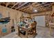 Unfinished basement with exposed beams and a worktable with storage underneath, offering a versatile space at 659 Willard Dr, Creedmoor, NC 27522