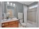Well-lit bathroom with a cherry wood vanity, framed mirror, and shower-tub combination at 659 Willard Dr, Creedmoor, NC 27522