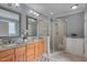 Double vanity bathroom featuring dual sinks, granite countertops, and a glass-enclosed shower at 659 Willard Dr, Creedmoor, NC 27522