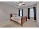 Neutral bedroom featuring plush carpet, two windows with decorative curtains, and a ceiling fan at 659 Willard Dr, Creedmoor, NC 27522