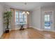 Bright dining room featuring hardwood floors, large window with backyard views and stylish chandelier at 659 Willard Dr, Creedmoor, NC 27522