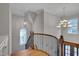 Open staircase with wood railing and decorative iron spindles, illuminated by elegant chandeliers at 659 Willard Dr, Creedmoor, NC 27522