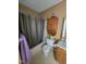 Simple bathroom featuring a shower with curtain, toilet, and overhead storage at 701 Grandview Drive Dr, Durham, NC 27703