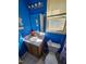 Compact blue bathroom featuring a single sink vanity and a window with blinds at 701 Grandview Drive Dr, Durham, NC 27703