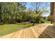 Expansive backyard with new wooden deck, lush lawn, storage shed, and mature trees for serene outdoor living at 714 W J St, Erwin, NC 28339