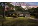 Charming brick home features manicured landscaping, a well-maintained lawn, and an inviting screened-in porch at twilight at 714 W J St, Erwin, NC 28339