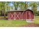 Outdoor shed with red siding, white trim, and a barn-style roof, providing ample storage space in the backyard at 714 W J St, Erwin, NC 28339