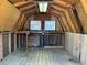 Shed interior with wooden framing, diamond-pattern flooring, two windows, and built-in shelving, offering storage potential at 714 W J St, Erwin, NC 28339