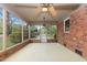 Bright sunroom with brick walls, ceiling fans, and large windows offering a serene view of the lush outdoors at 714 W J St, Erwin, NC 28339