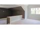 Upstairs bonus room with dark accent wall and a window at 7412 Wexford Woods Ln, Wake Forest, NC 27587