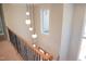 Modern staircase with metal railing and hanging globe lights at 7412 Wexford Woods Ln, Wake Forest, NC 27587
