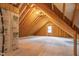 An unfinished attic space showing wood framing, a small window and potential for storage or renovation at 8621 Bishop Pine Ln, Wake Forest, NC 27587