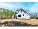Spacious backyard view of a two-story home with an expansive lawn and green trees on a bright sunny day at 8621 Bishop Pine Ln, Wake Forest, NC 27587