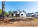 An expansive backyard showcasing the modern home with a patio, lawn and surrounding trees at 8621 Bishop Pine Ln, Wake Forest, NC 27587