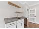 Wet bar with floating shelves, quartz counters and gold hardware at 8621 Bishop Pine Ln, Wake Forest, NC 27587