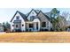 Striking home with stone and white siding, complemented by a well-maintained lawn and landscaping at 8621 Bishop Pine Ln, Wake Forest, NC 27587