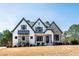 Beautiful new construction home featuring a combination of stone and white siding with black trim at 8621 Bishop Pine Ln, Wake Forest, NC 27587