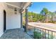 Cozy front porch with stone tile flooring, white brick siding, and an overhead pendant light at 8621 Bishop Pine Ln, Wake Forest, NC 27587