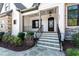 Charming front porch with a welcoming entrance, black iron railings, and well-maintained landscaping at 8621 Bishop Pine Ln, Wake Forest, NC 27587