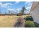 Spacious backyard with multiple storage sheds and landscaping on a partly cloudy day at 107 Rollingwood Cir, Kenly, NC 27542
