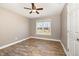 Bedroom with hardwood floors, ceiling fan, and a window overlooking the outdoor landscape at 107 Rollingwood Cir, Kenly, NC 27542
