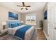 Staged bedroom with hardwood floors, ceiling fan, and a window showcasing the outdoor landscape at 107 Rollingwood Cir, Kenly, NC 27542