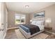 Bedroom featuring a large bed with a neutral color scheme, wood flooring, and natural light from the window at 107 Rollingwood Cir, Kenly, NC 27542