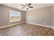 An empty bedroom with hardwood floors, a ceiling fan, and a large window for great natural light at 107 Rollingwood Cir, Kenly, NC 27542