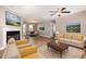 Bright living room with a fireplace, hardwood floors, and an open floor plan into the dining room at 107 Rollingwood Cir, Kenly, NC 27542