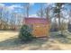 Wooden storage shed with a red roof and small window adds character to the backyard at 107 Rollingwood Cir, Kenly, NC 27542