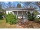 Charming front entrance with concrete steps and covered porch, framed by lush greenery at 110 W Elm St, Nashville, NC 27856