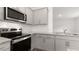 Close-up of modern stainless appliances, granite countertops, gray cabinets and white subway tile backsplash in kitchen at 139 Ethel Ln, Angier, NC 27501