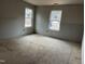 Spacious bedroom featuring two bright windows and unfinished floors, ready for customization at 1516 Bragg St, Sanford, NC 27330