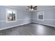 A bright bedroom with modern gray floors, fresh, light blue paint and white trim on windows at 1729 Augustus Dr, Rocky Mount, NC 27801
