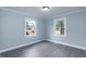 A bright bedroom with modern gray floors and fresh, light blue paint with white trim at 1729 Augustus Dr, Rocky Mount, NC 27801