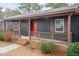 Cozy front porch with brick steps, decorative railing, and a striking red front door at 1729 Augustus Dr, Rocky Mount, NC 27801