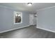 Living room featuring neutral paint with gray wood-look flooring and a window view of the front yard at 1729 Augustus Dr, Rocky Mount, NC 27801