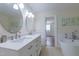 Bathroom boasts a double sink vanity, tile flooring, and a standalone tub, bright with natural light at 2010 Twin Acres Rd, Clayton, NC 27520